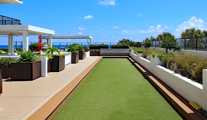 Artificial grass installed on a rooftop terrace with planters