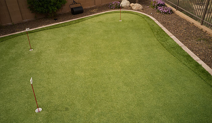 Artificial golf course putting green featuring multiple holes and a flag