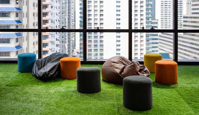 Indoor lounge area in a commercial property featuring artificial turf flooring with colorful bean bags