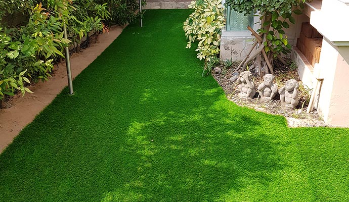 Synthetic turf installed in a residential backyard with green landscaping